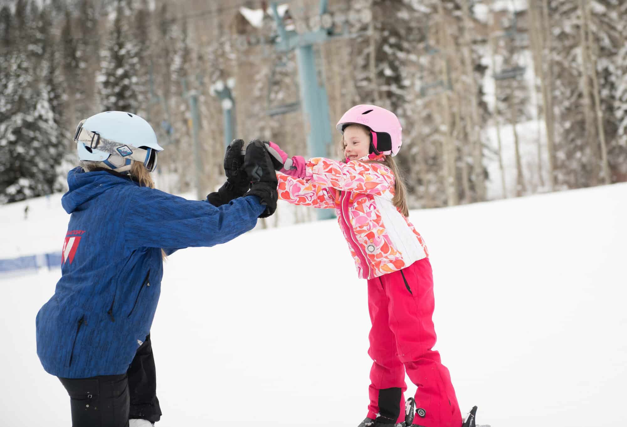 Young girl high fives her instructor