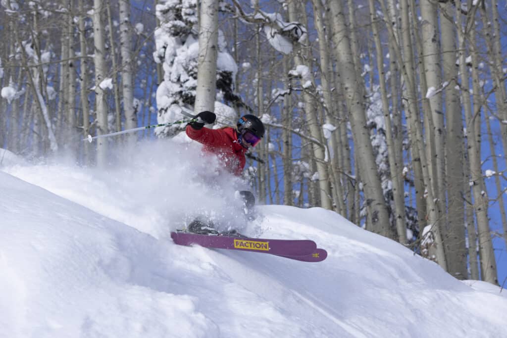 Girls skier turns through the aspens on a powder day