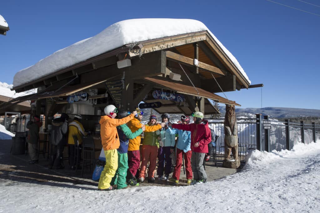Friends in ski clothes cheers at the Bear Bar
