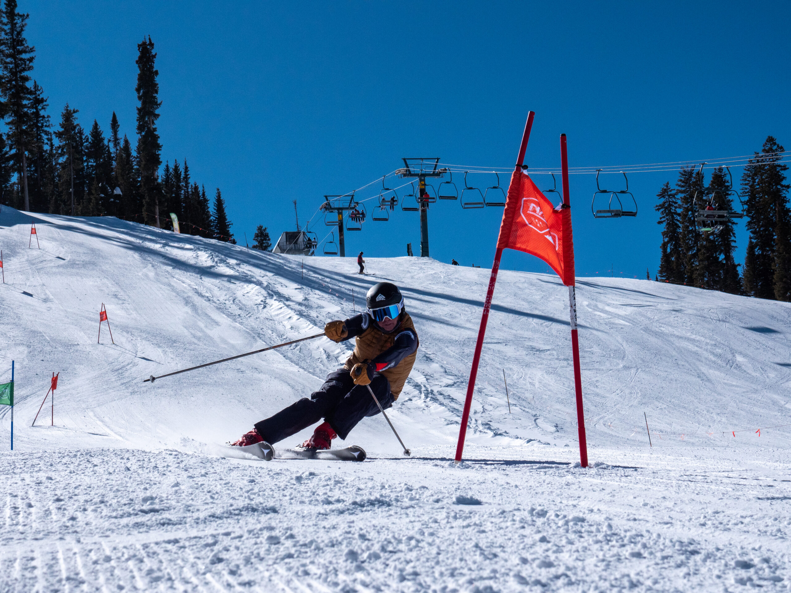 A skier carves around a slalom gate on a snowy slope