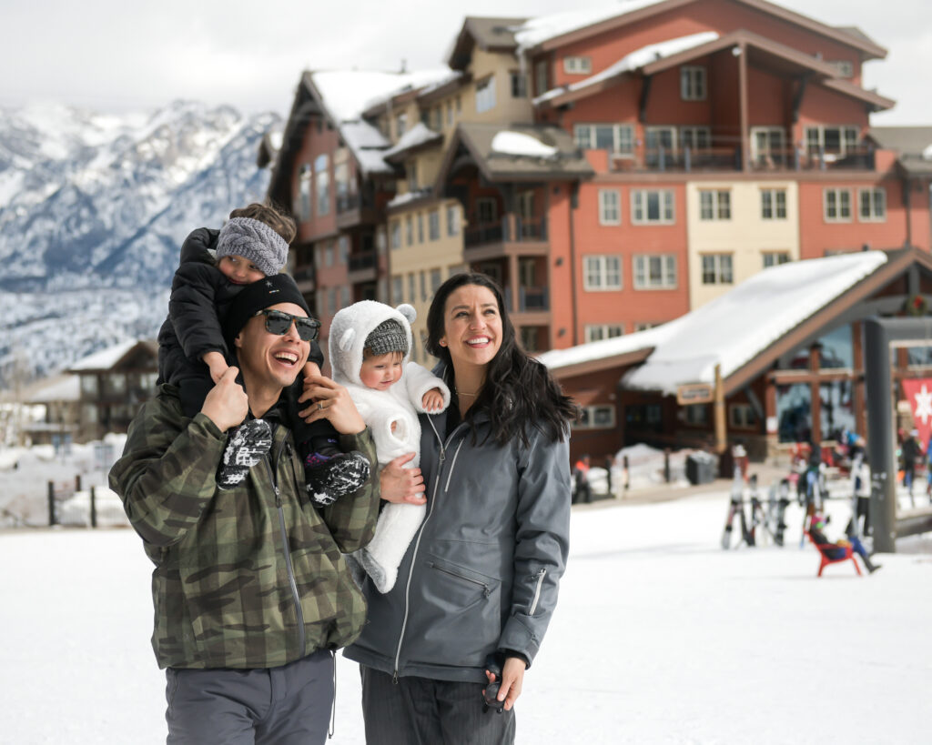 A family smile together at the ski resort base area