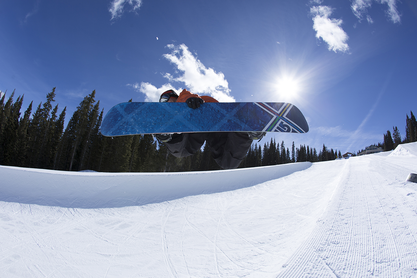 A snowboarder catches air off the half pipe feature