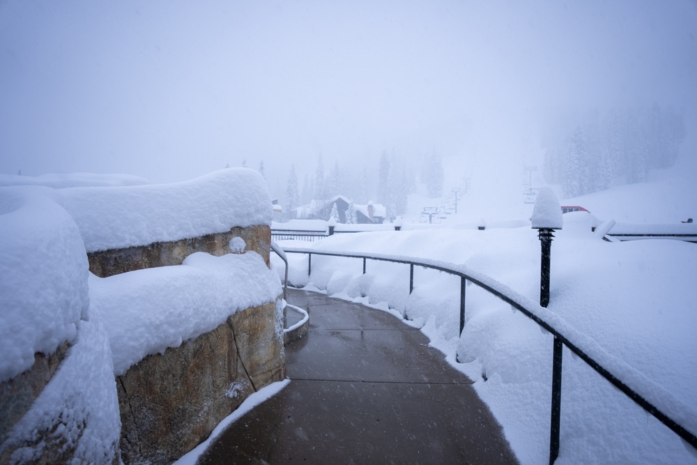 Snow piles up on the sides of the pool and hot tub