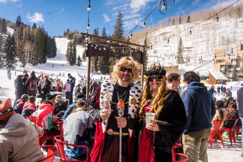 A man and woman pose together at the base area in their Shakespearean costumes