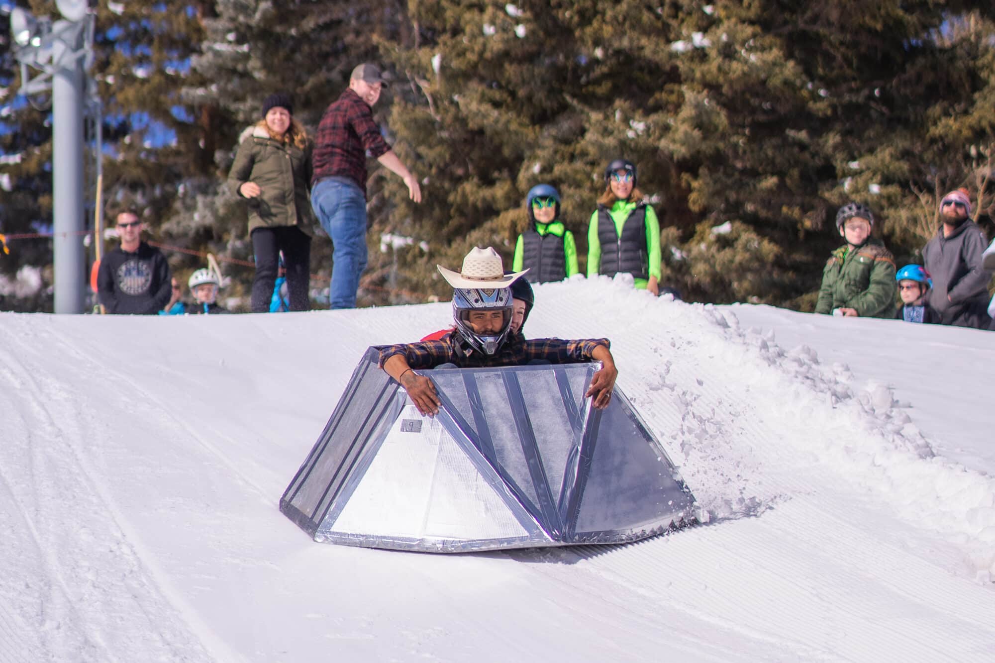 Two individuals in a cardboard derby wearing costumes