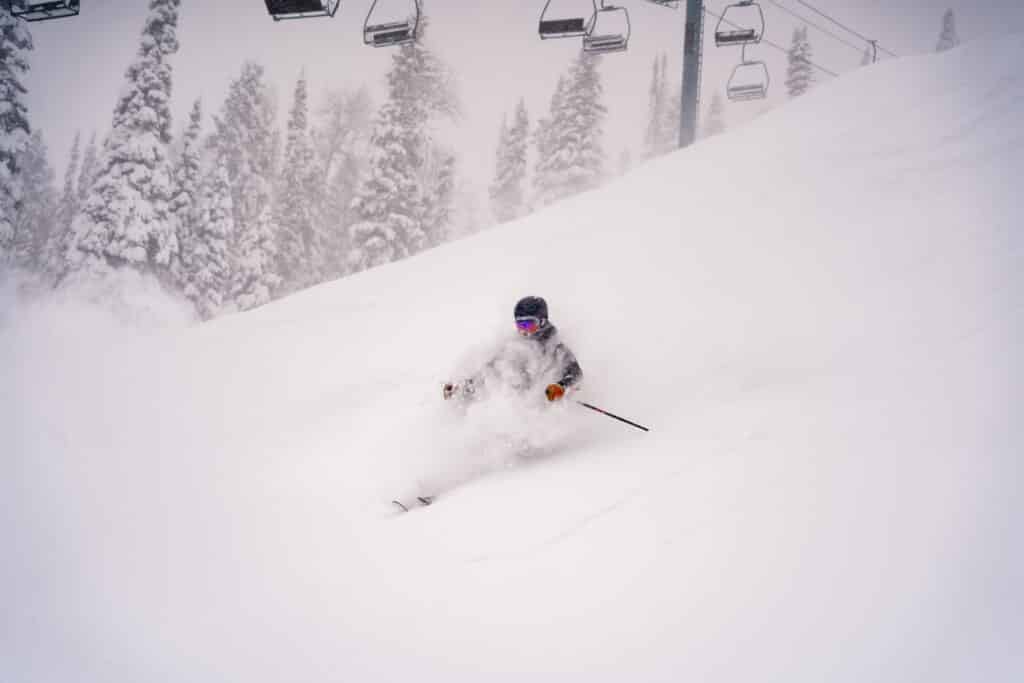 A skier rides through powder