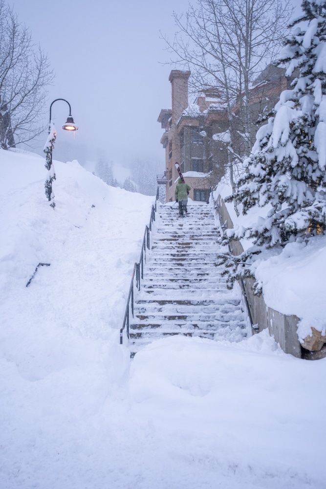 A skier walks up stairs