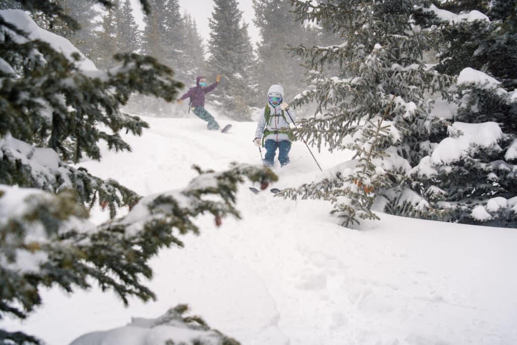 Two people navigating through powder