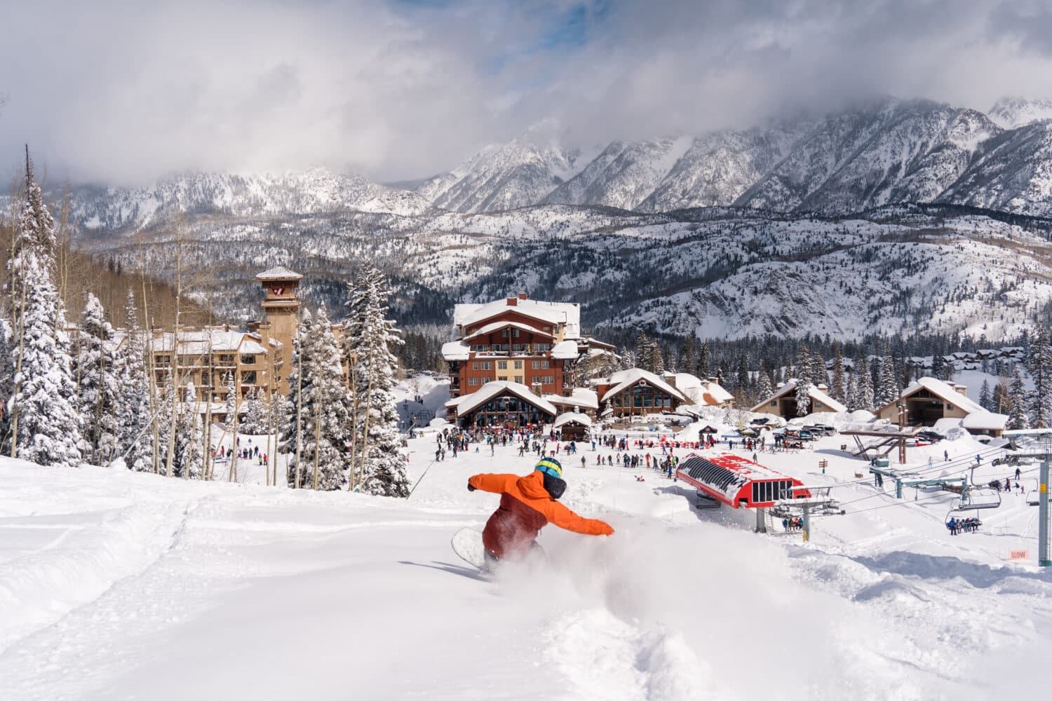 A snowboarder sends up powder on the slopes