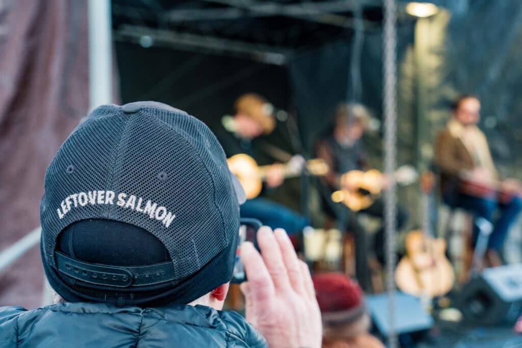 A man wears a hat that reads "Leftover Salmon"