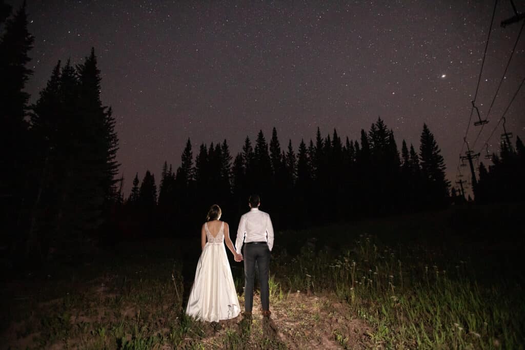 a bride and groom side by side at night