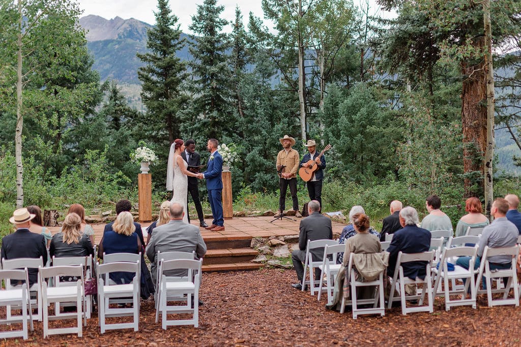 a bride and groom participate in a wedding ceremony in an alpine setting