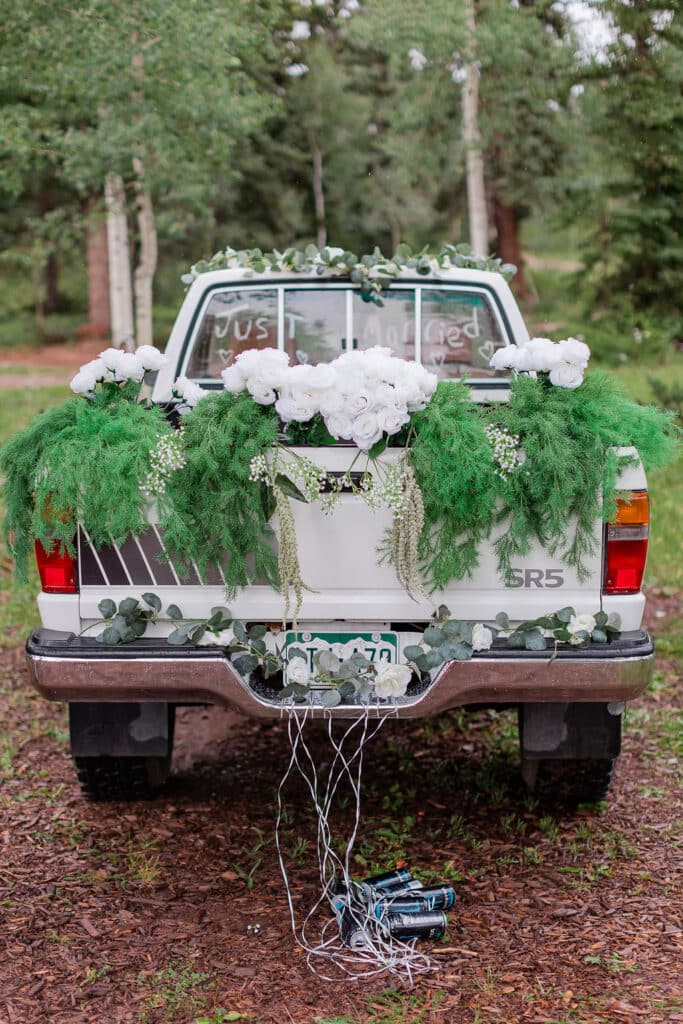 "Just Married" a truck with flowers and greenery in the back