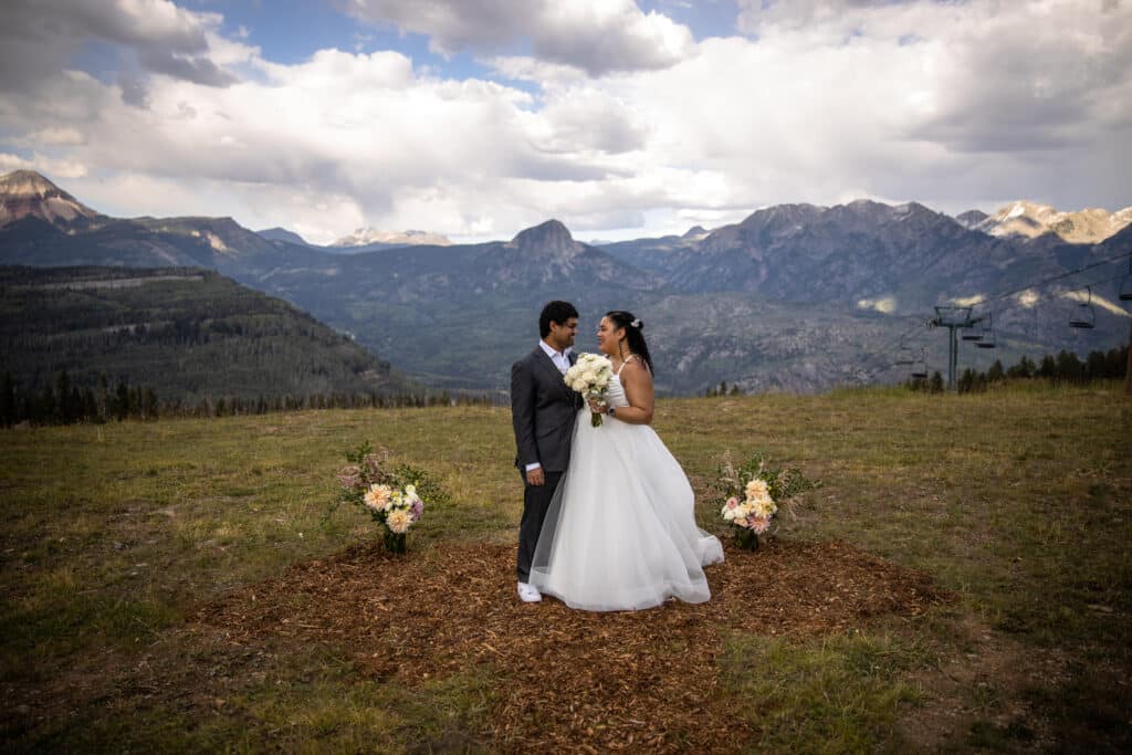 A bride and groom with mountains in the background