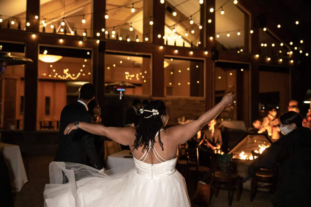 A bride dancing on a fire-lit patio at Purgy's