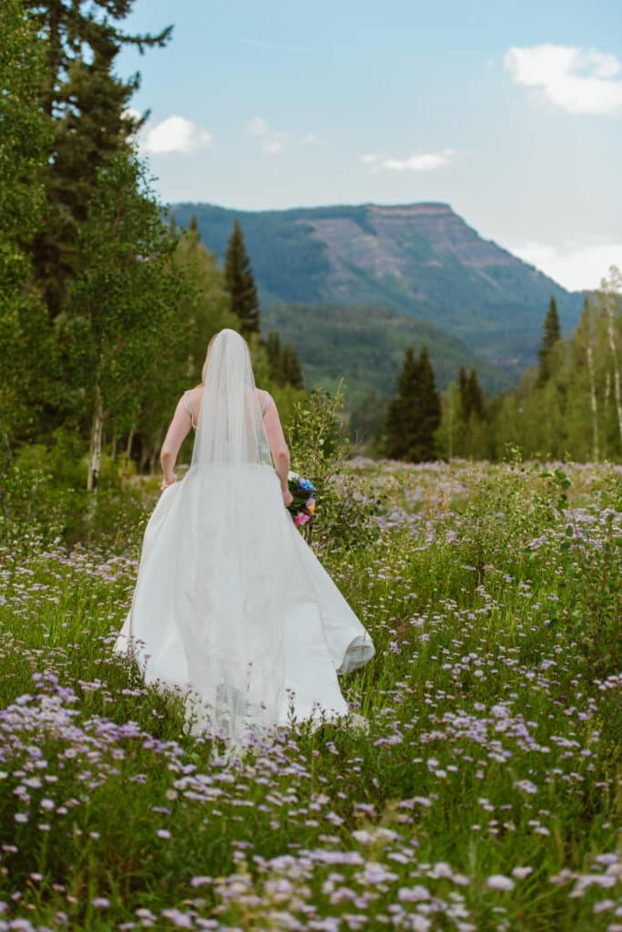 A bride walks through wildflowers