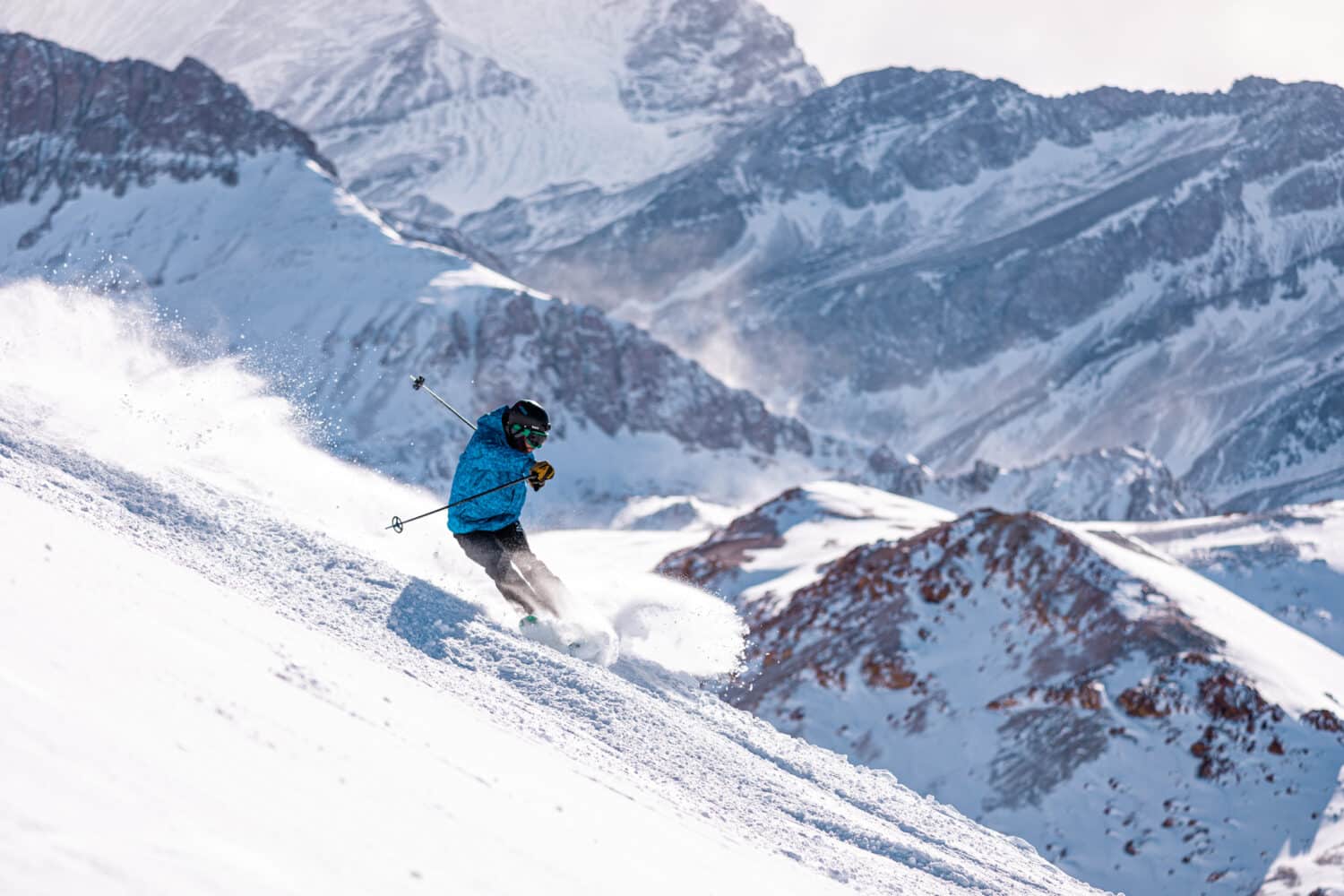 A skier carves on a steep mountain side at Valle Neavado