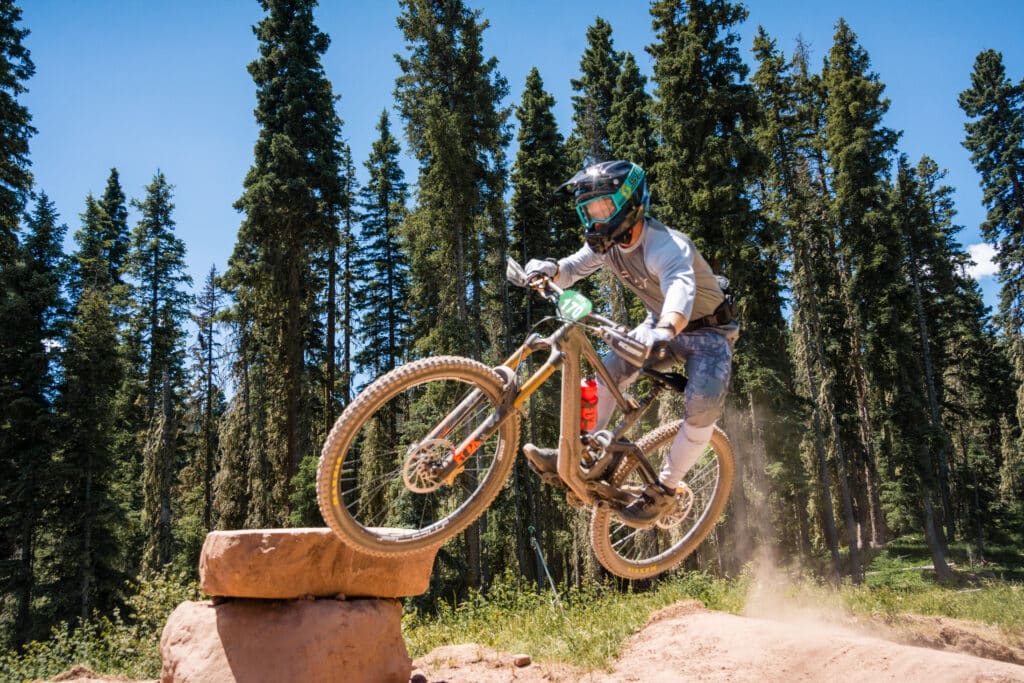 A mountain biker jumps on their bike