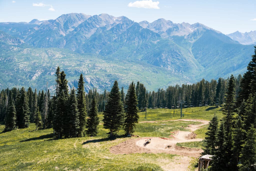 Cyclists ride on dirt trails in the mountains