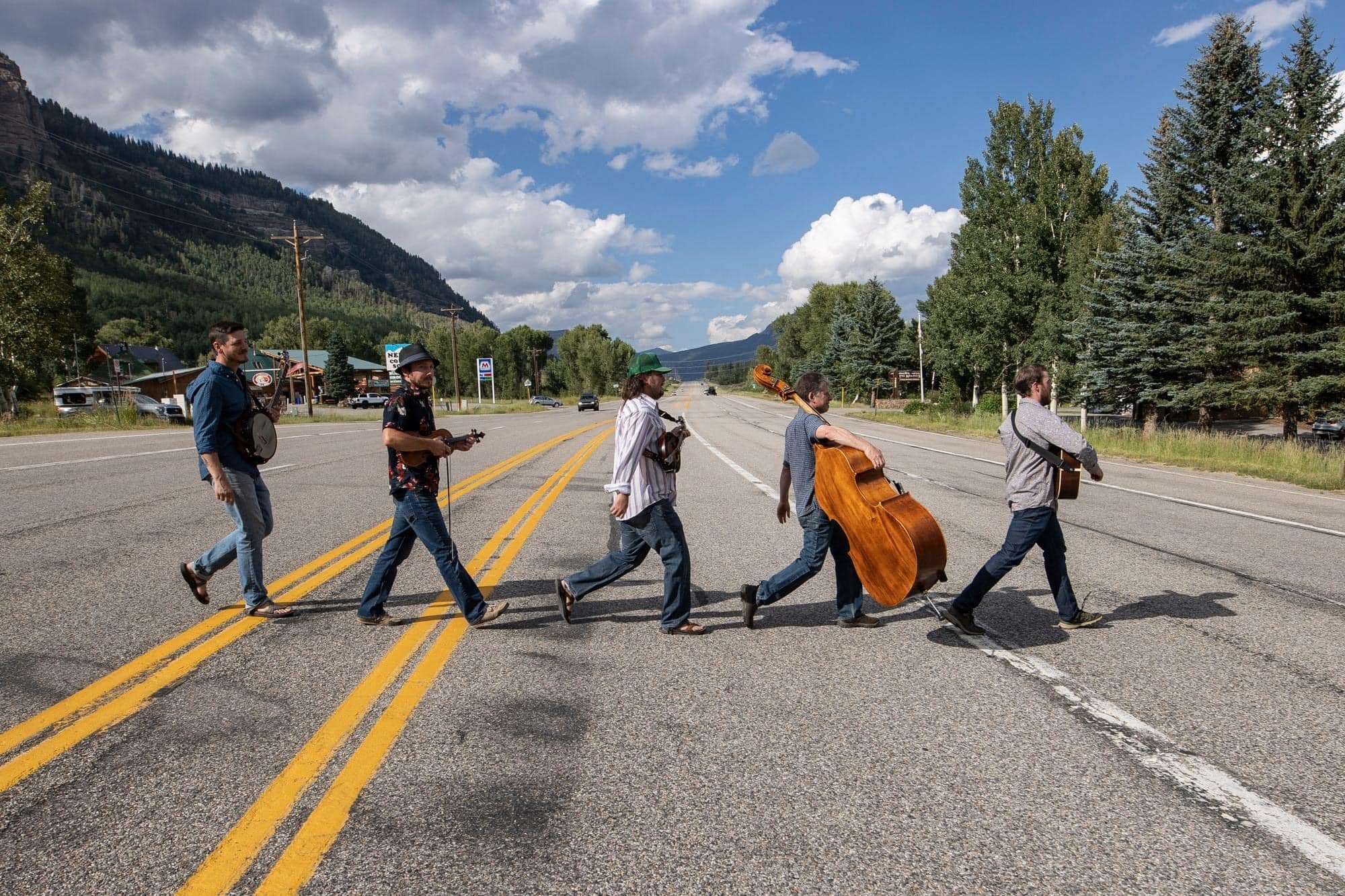 band members walk across a mountain highway