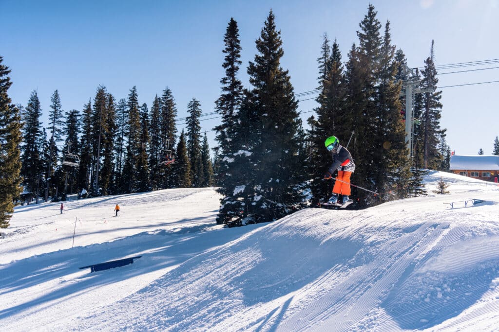 a kid catches air off a ski jump
