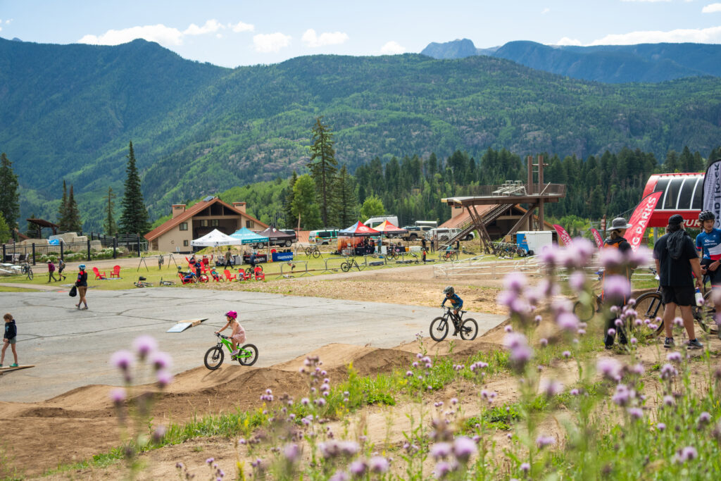 Kids ride bikes around the base area at Purgatory Resort