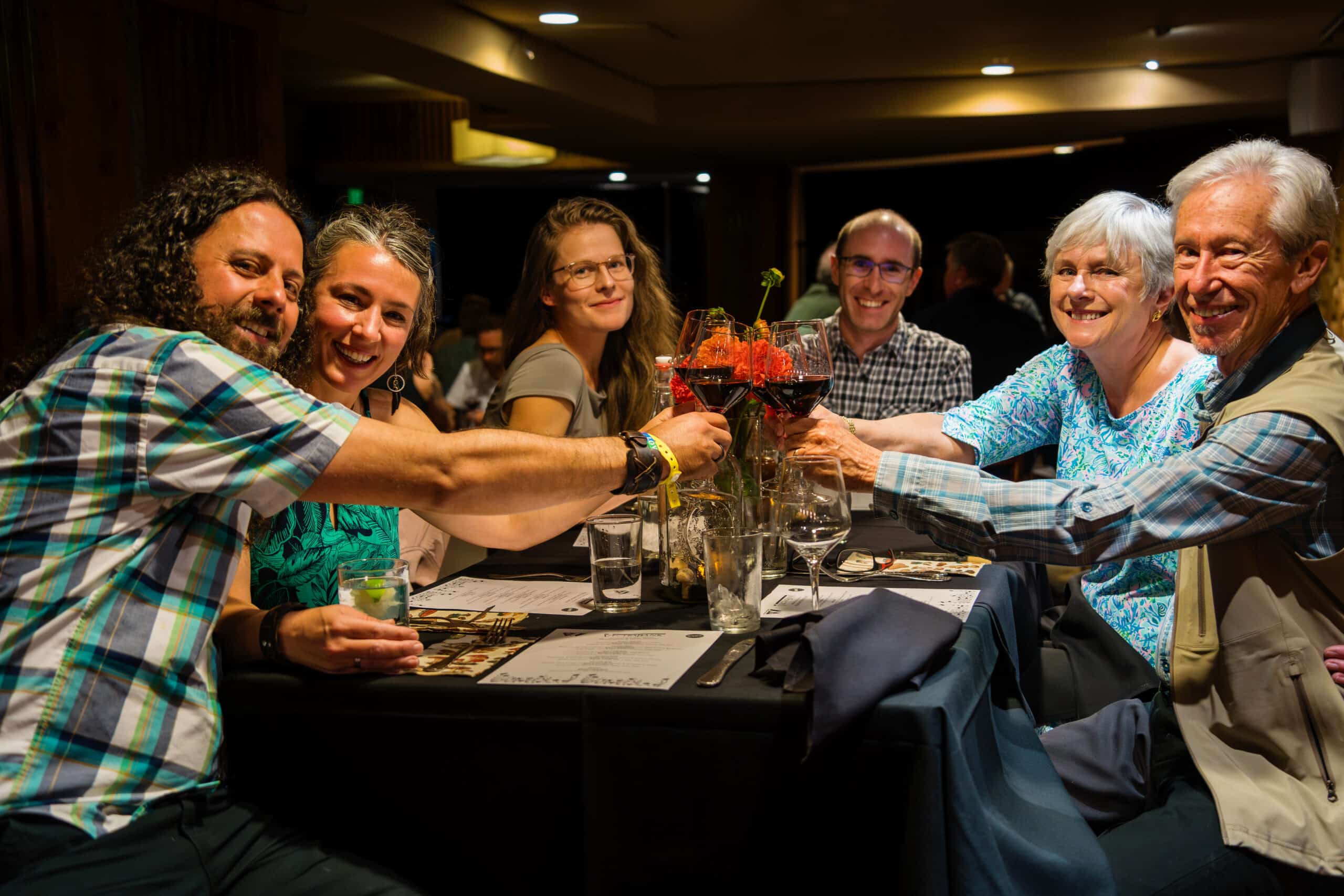 Friends cheers over their table at the Mushroom Dinner