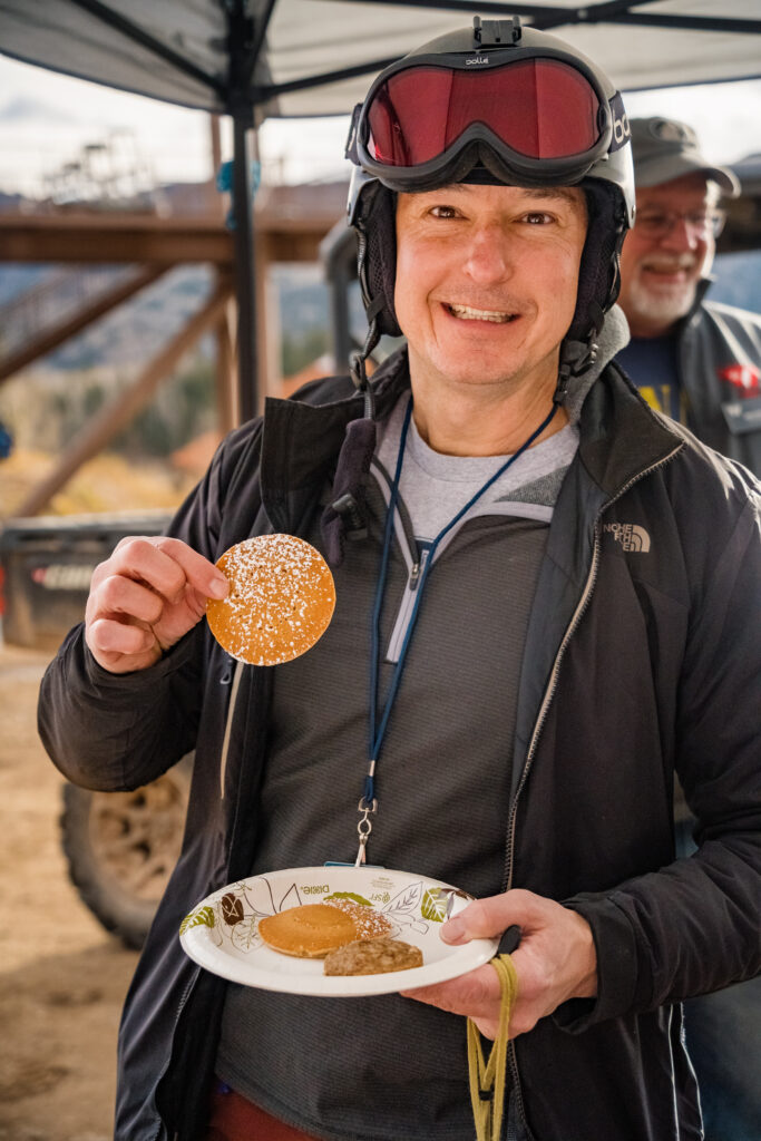 A skier enjoys pancakes in the lift line on opening day