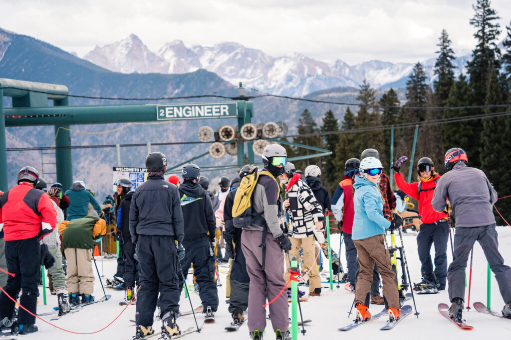 Skiers and riders wait in the lift line on opening day