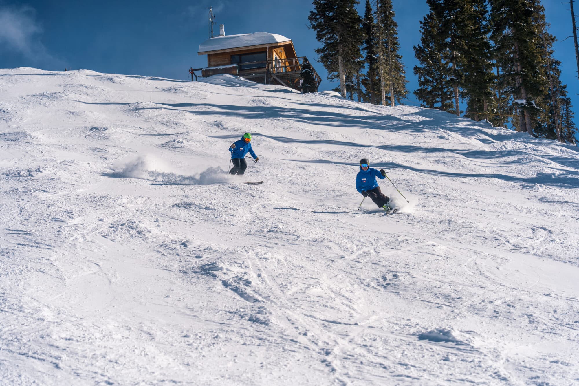 Instructors race down a black mogul run