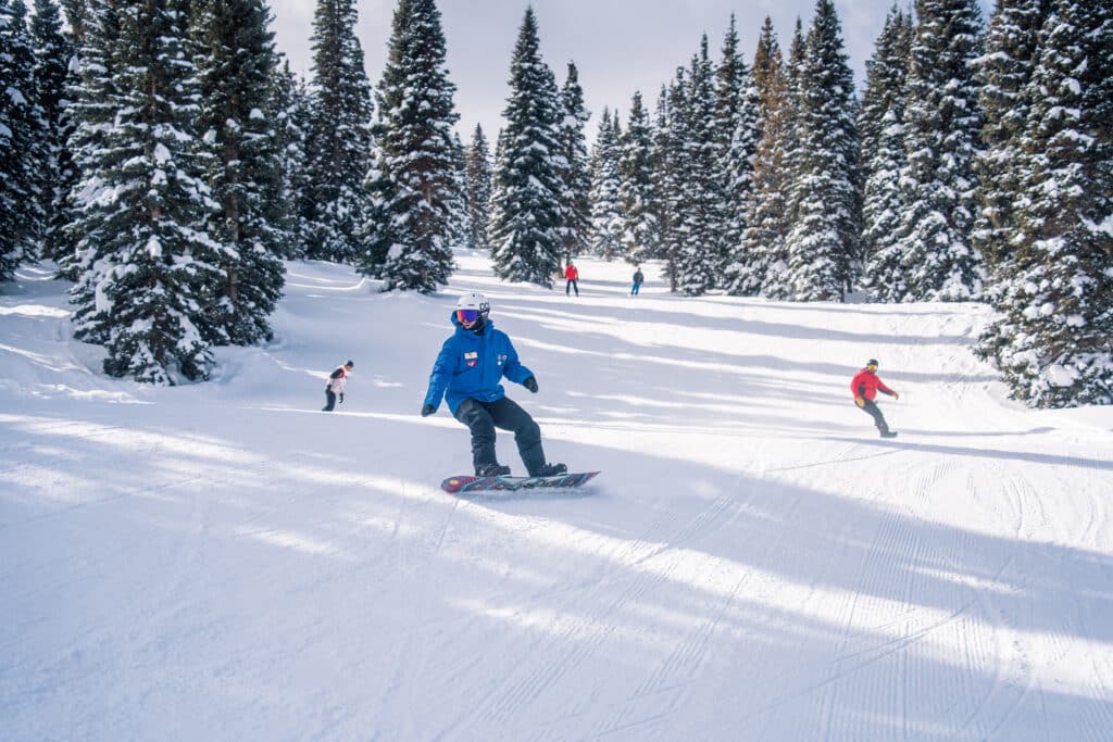 Snowboard instructor shows good form will his group follows