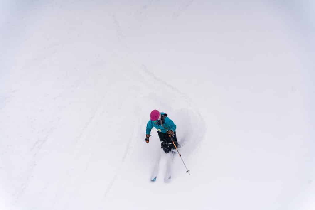 Skier cuts fresh tracks down a powder covered slope