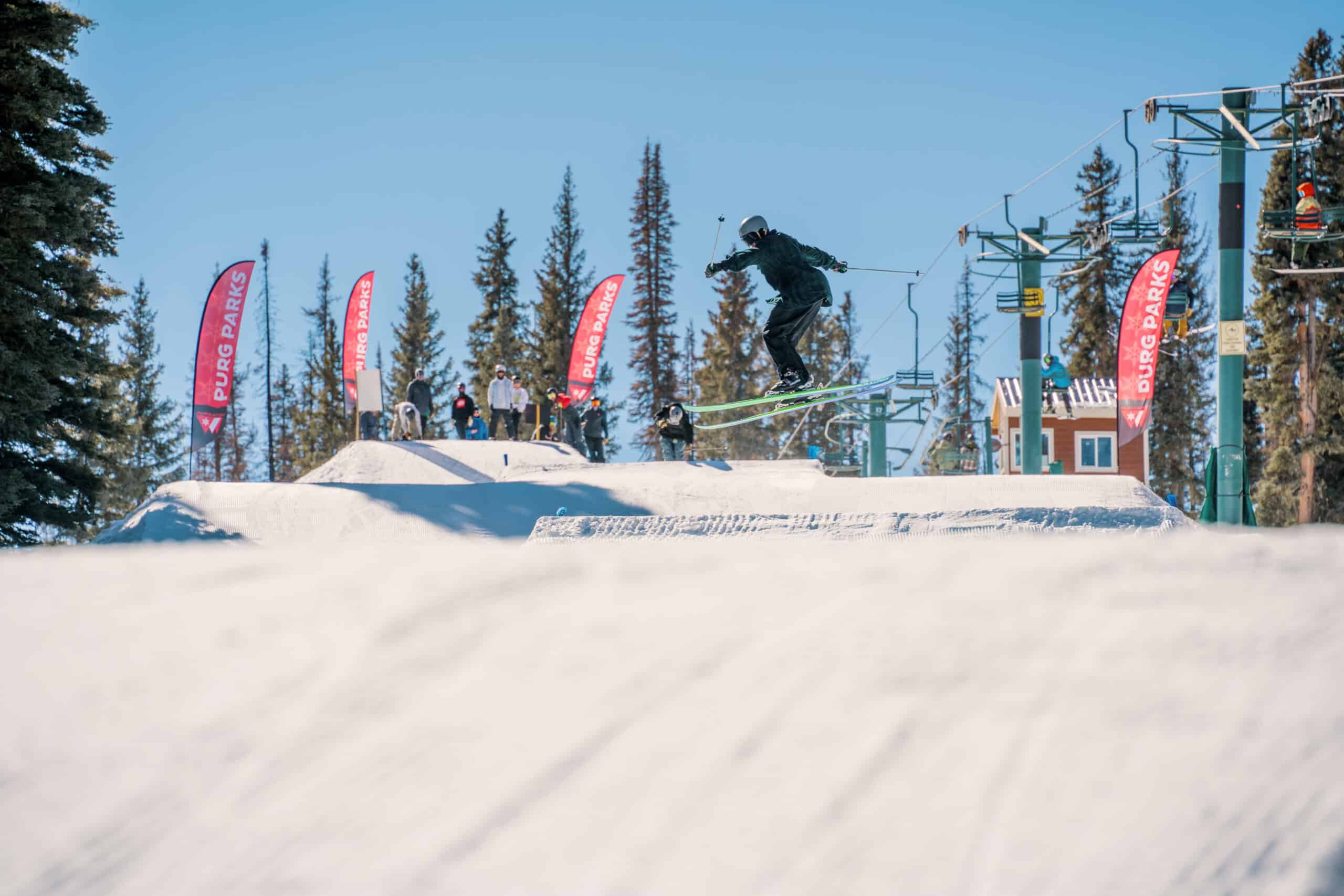 a skier catches air off a feature in the terrain park at Purgatory Resort