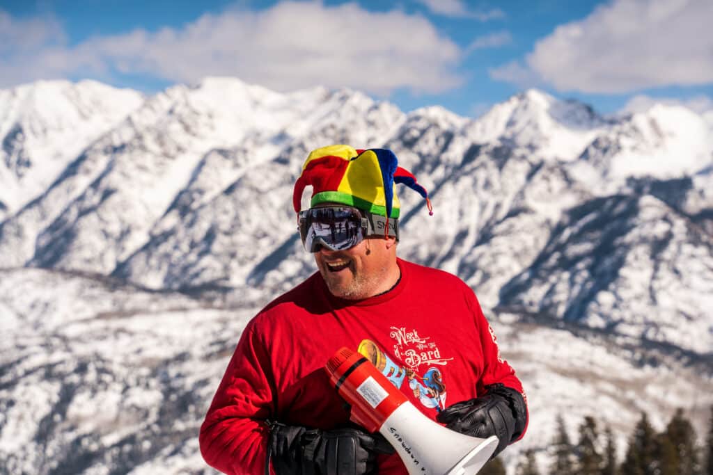 man in a jester hat with mountains in the background