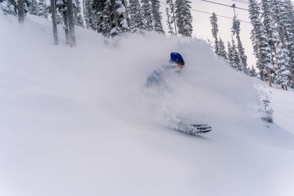 A person riding through deep snow on the slopes