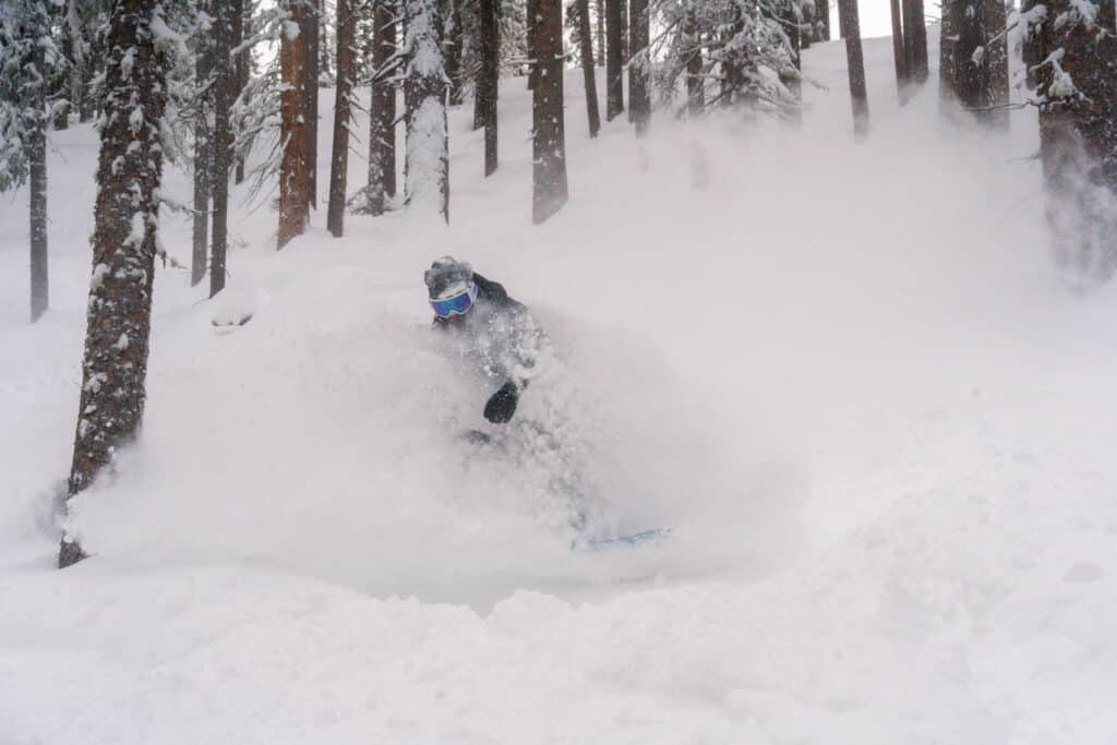 A snowboarder in deep powder 2.7.24