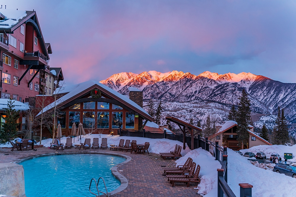 Alpenglow light on the mountains with the pool at Purgatory Lodge in the foreground