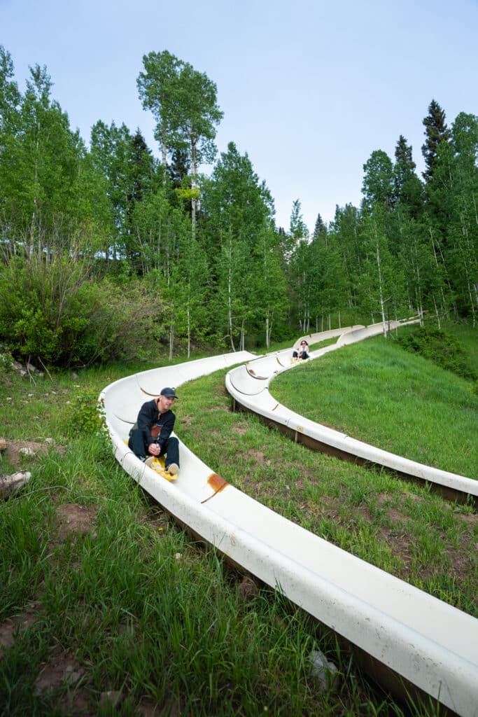 two people riding down the alpine slide