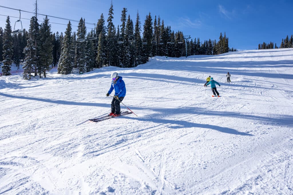 Ski instructor leads the way for his adult group to follow