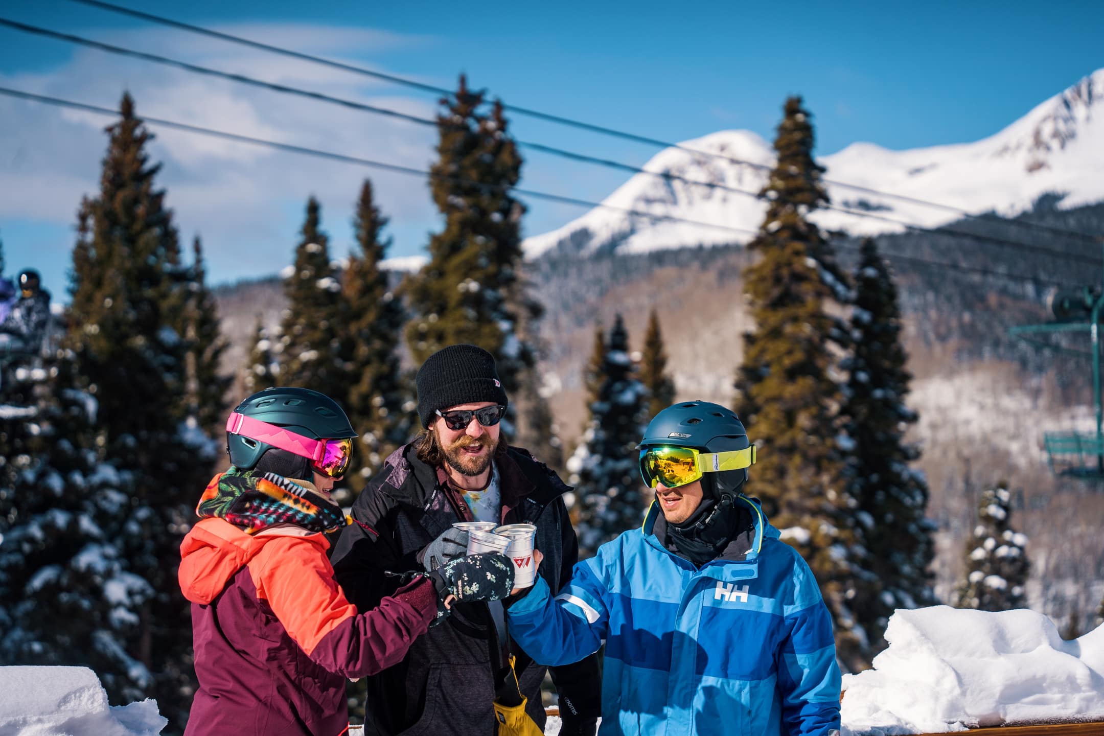 Group of friends cheers at the powderhouse deck after getting their beers with fun fund credits!