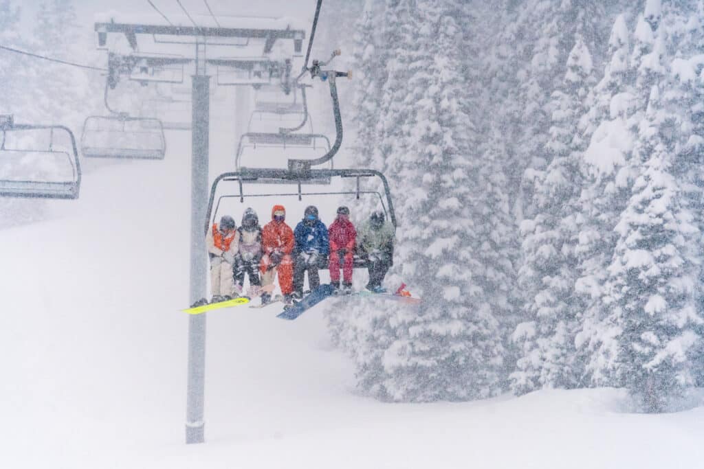 riders take the lift up in a snow storm