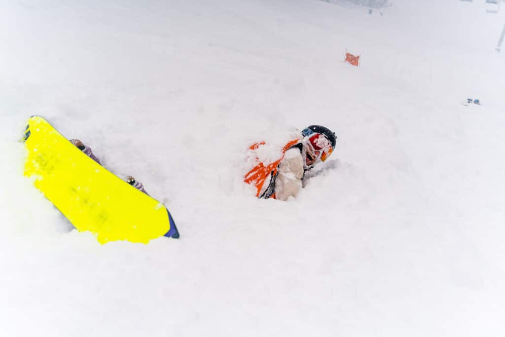 snowboarder buried in powder