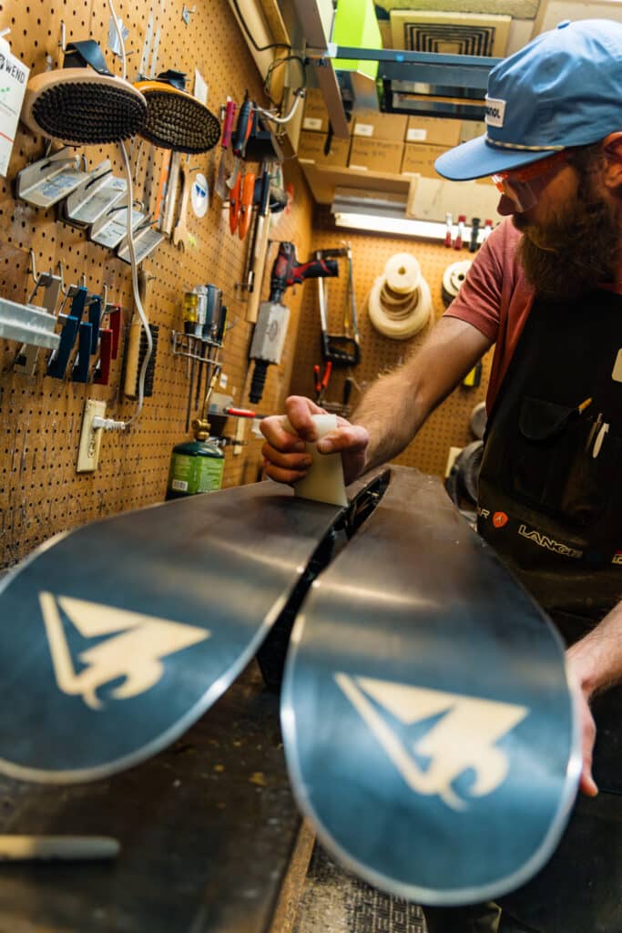 Expert Edge expertly tuning skis in shop