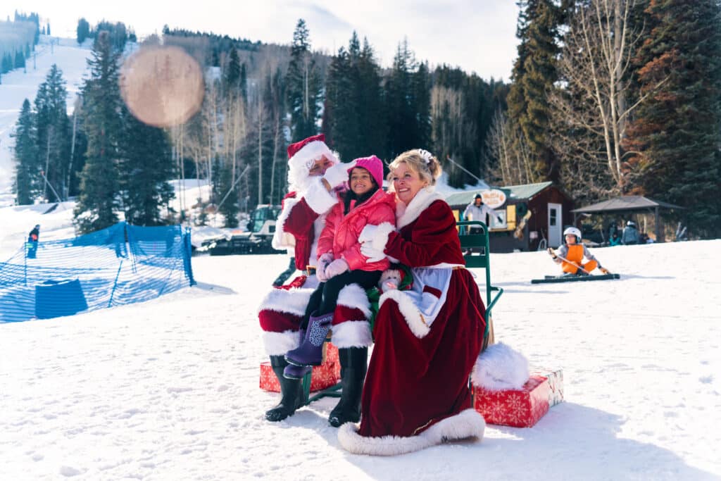 A kid smiles on Santa's lap