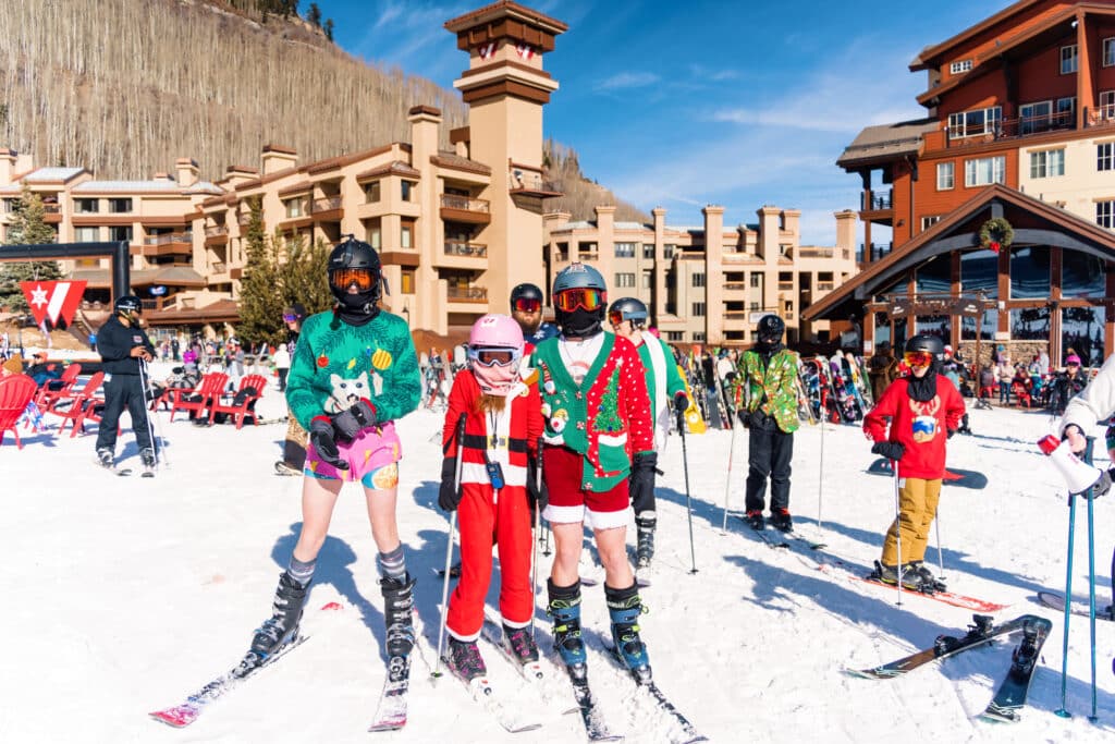 A trio in Christmas sweaters pose for a pic