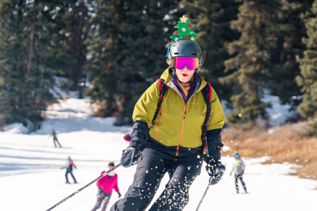 Skier with Christmas tree on her head tears it up on a groomer