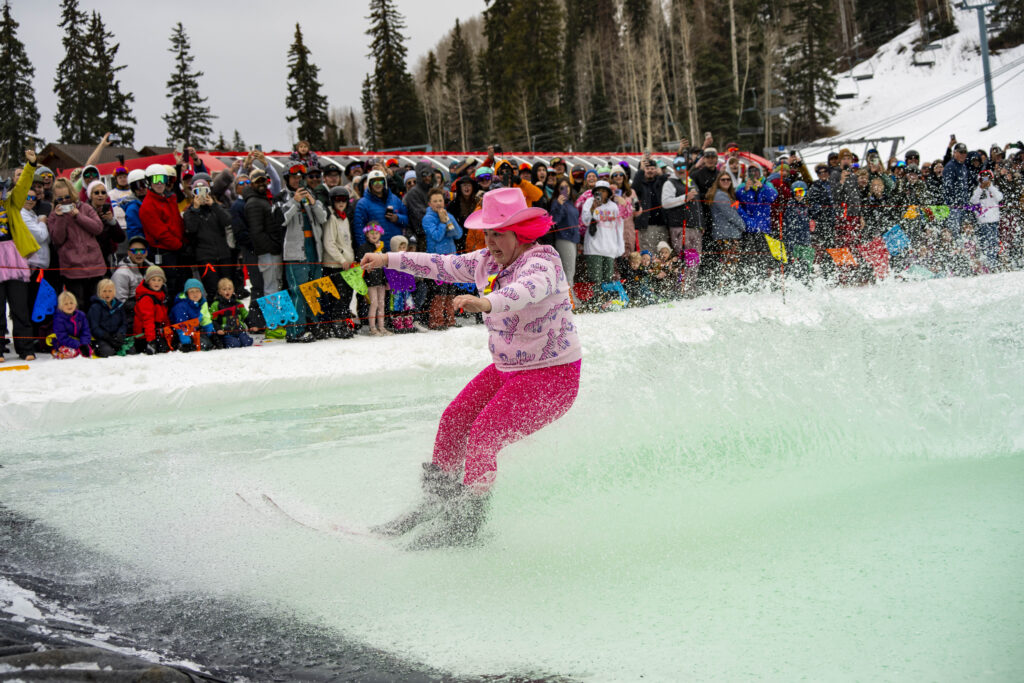 Female Skier decked out in all pink makes it to the end of the pond skim at Purgatory Reosrt