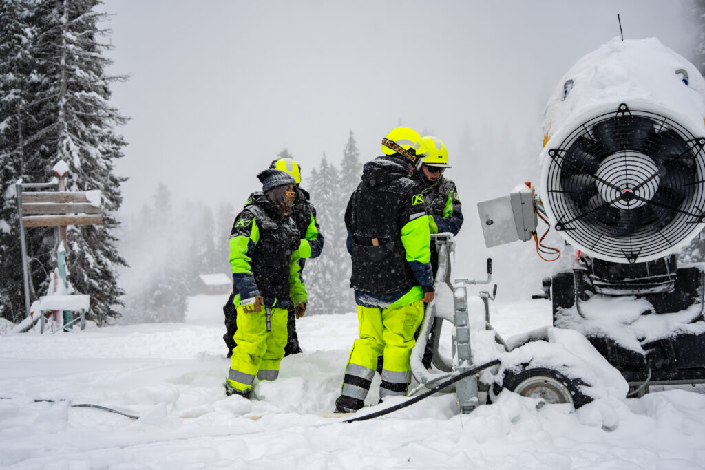 Purgatory's snowmaking team gathered around a snowmaking fan gun