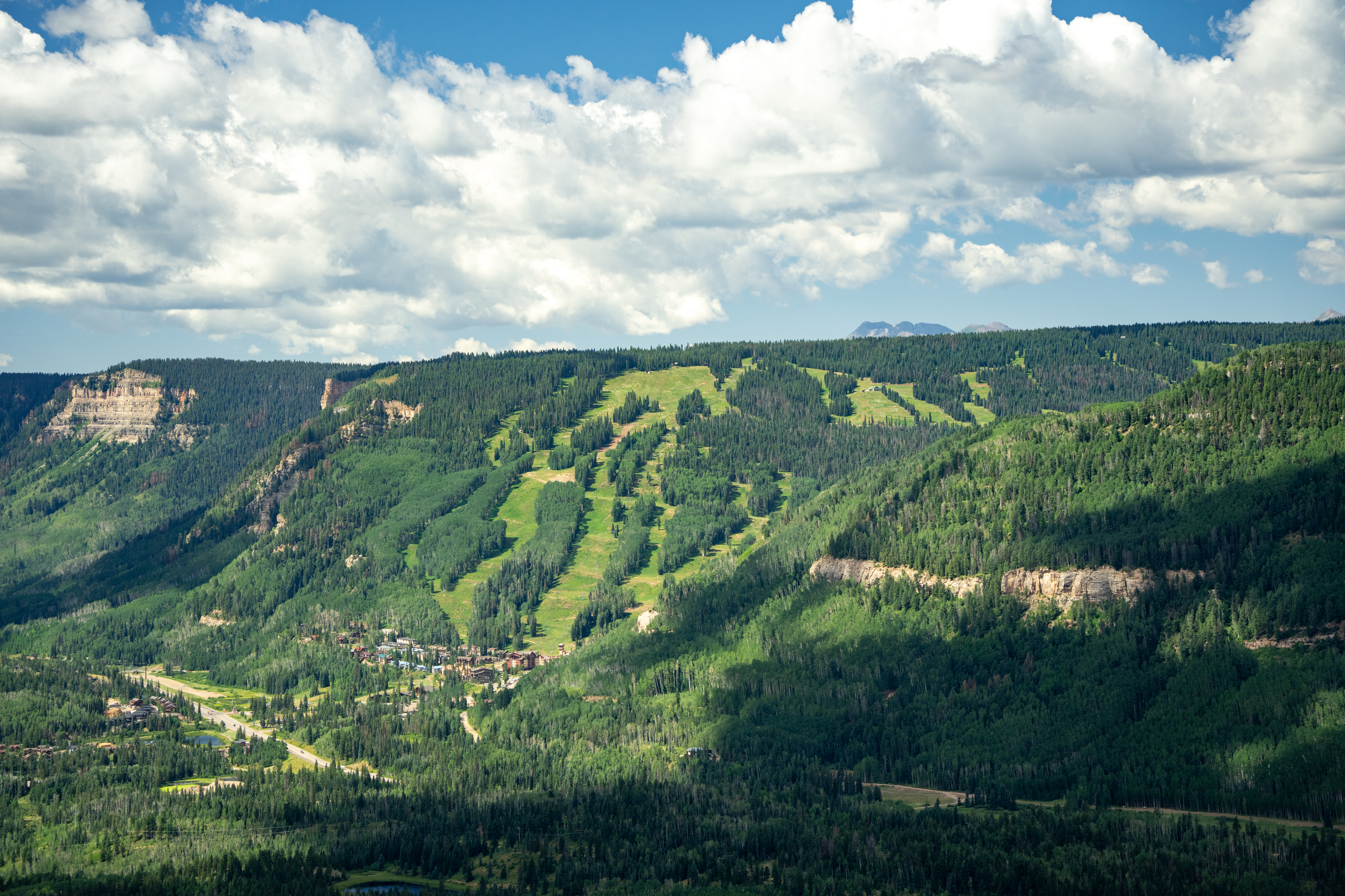 Arial drone image looking at Purgatory Resort covered in lush green during spring