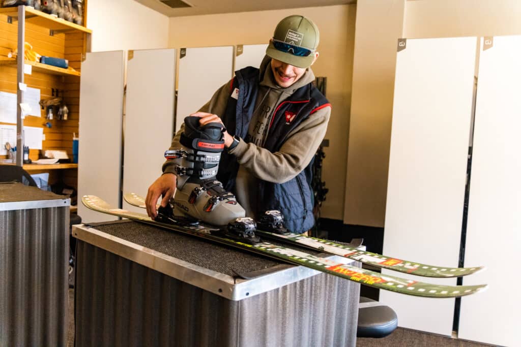 Employee at Expert Edge helps set up Demo Skis